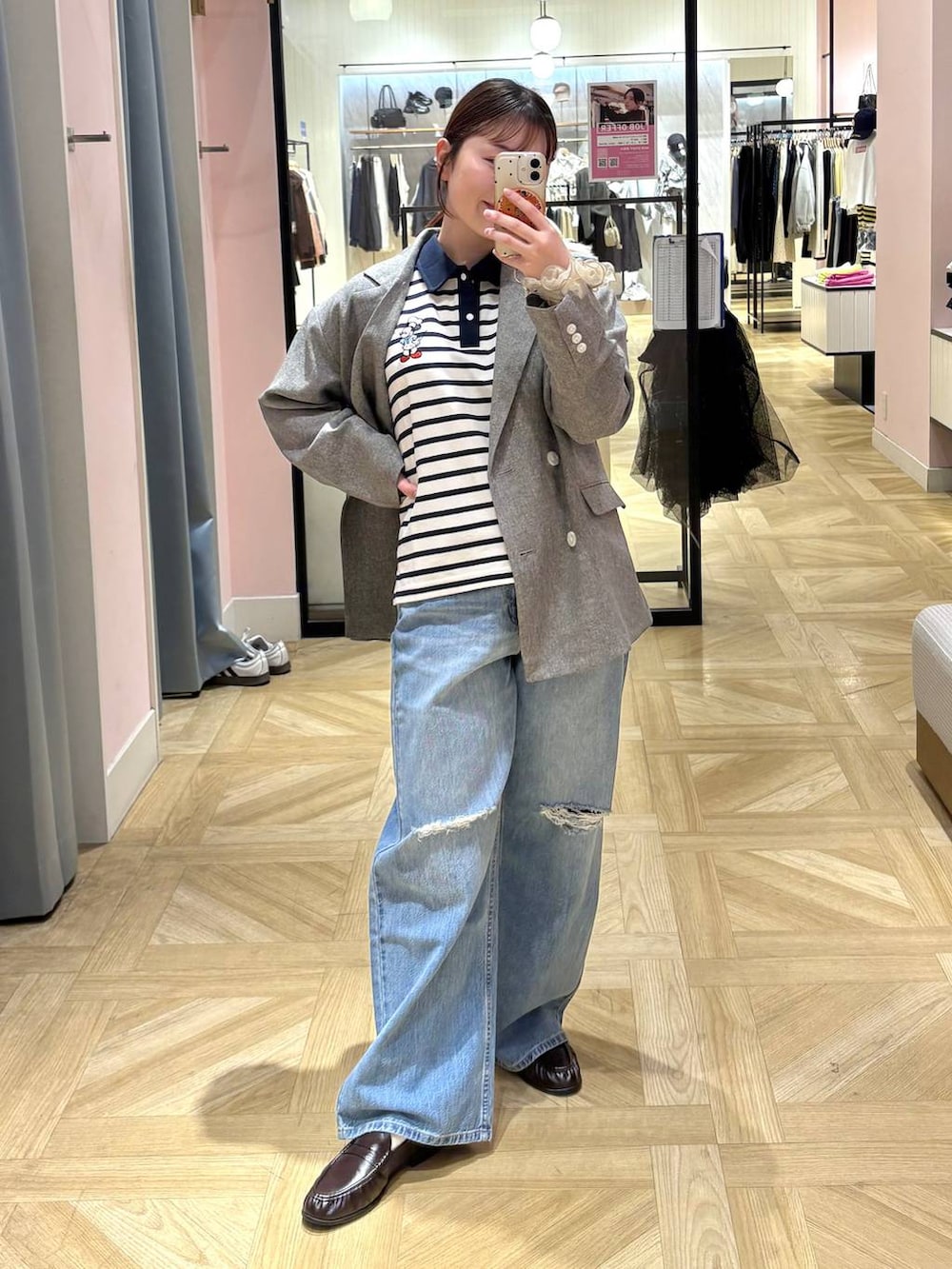 グレー系のテーラードジャケット、ブルー系のデニムパンツ、ブラウン系のローファーを着用したレディースの春コーディネートの3枚目の写真