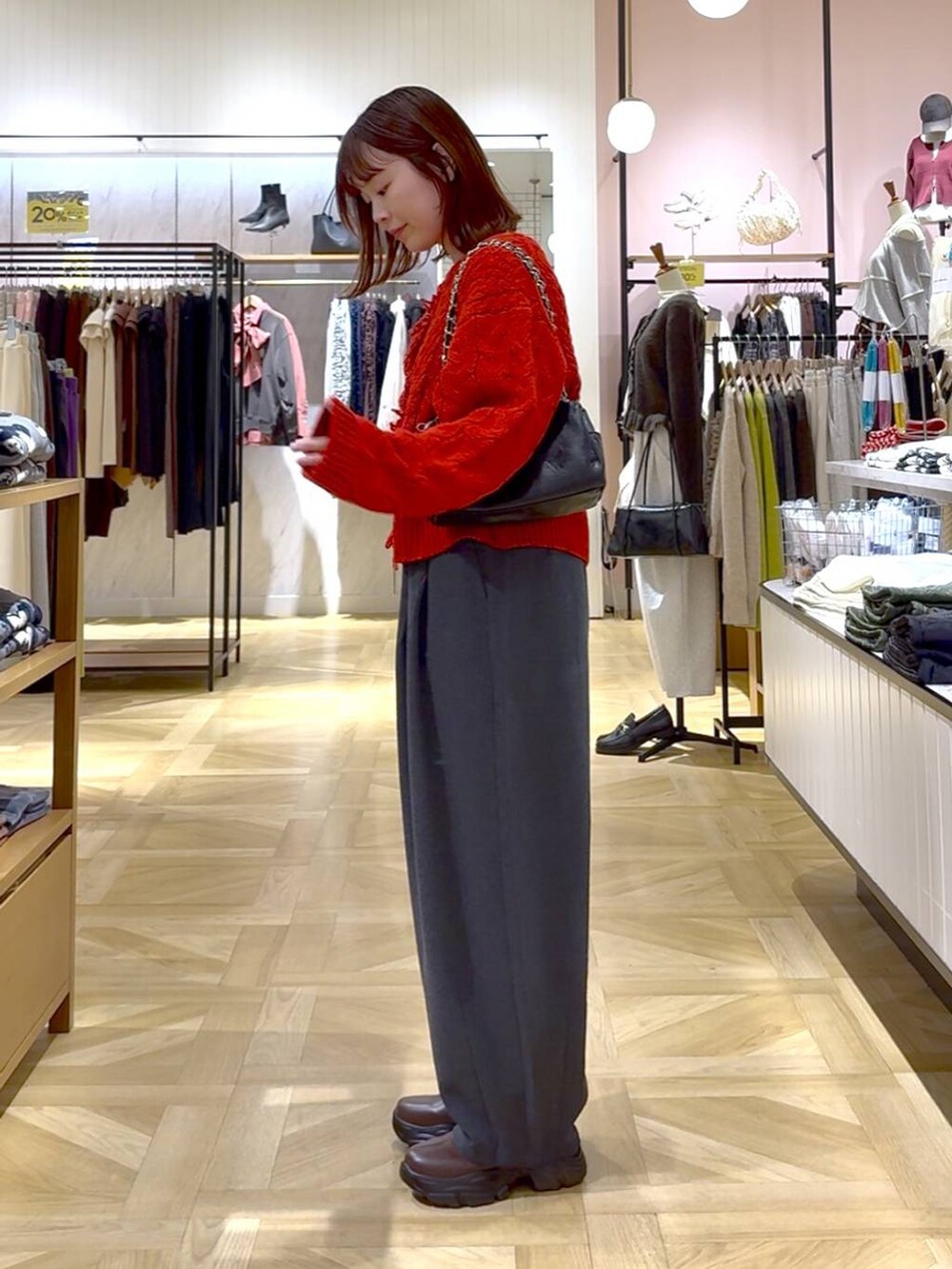 グレー系のその他パンツ、レッド系のポロシャツ、ブラック系のショルダーバッグを着用したレディースの秋コーディネートの2枚目の写真