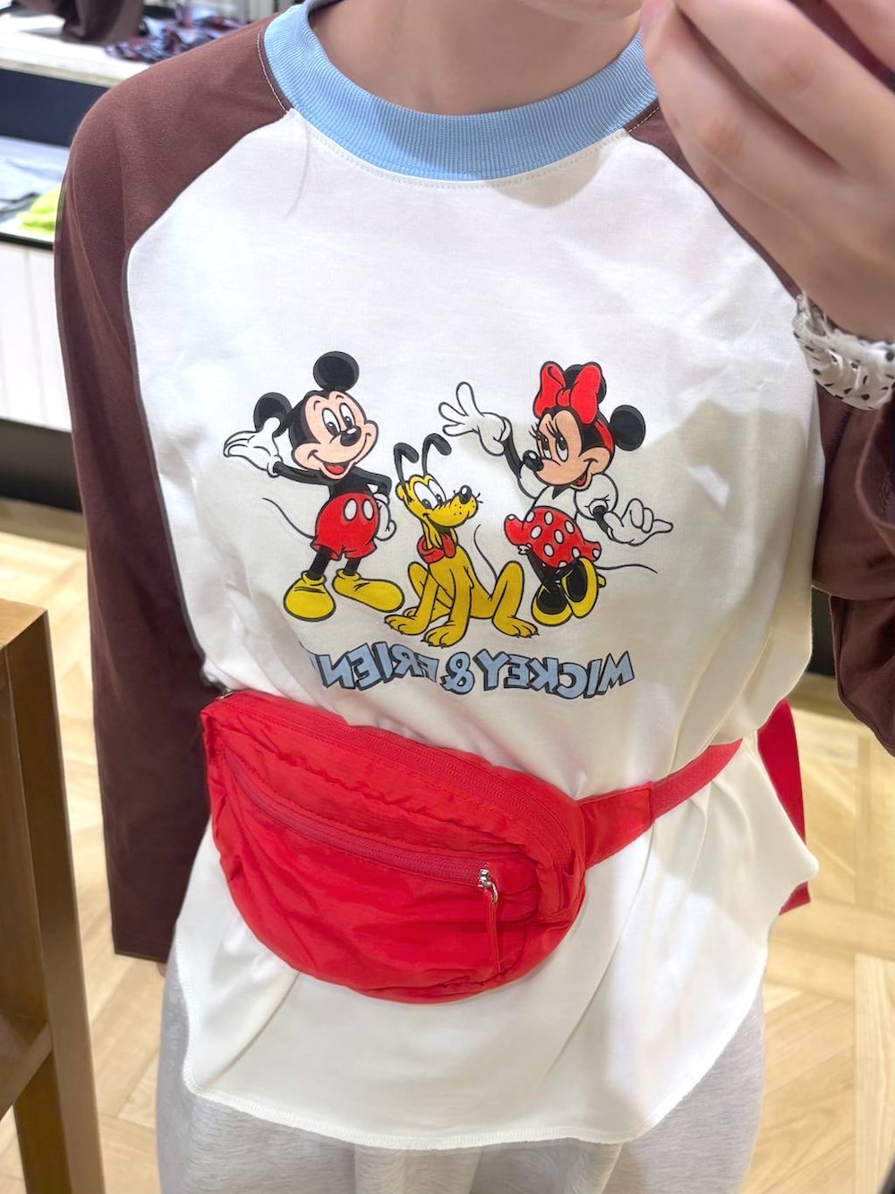 ベージュ系のTシャツ/カットソー、グレー系のスウェットパンツ、レッド系のボディバッグ/ウエストポーチを着用したレディースの秋コーディネートの4枚目の写真