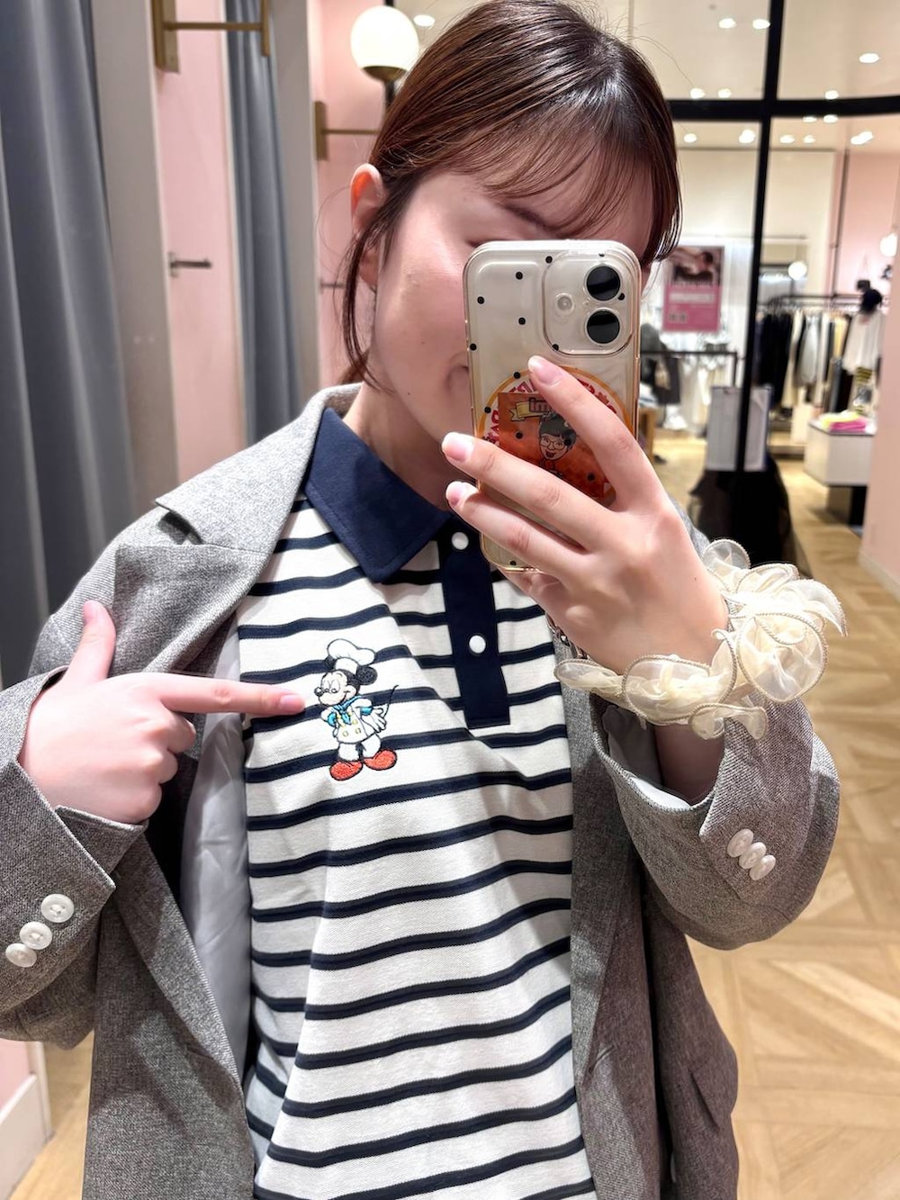 グレー系のテーラードジャケット、ブルー系のデニムパンツ、ブラウン系のローファーを着用したレディースの春コーディネートの2枚目の写真