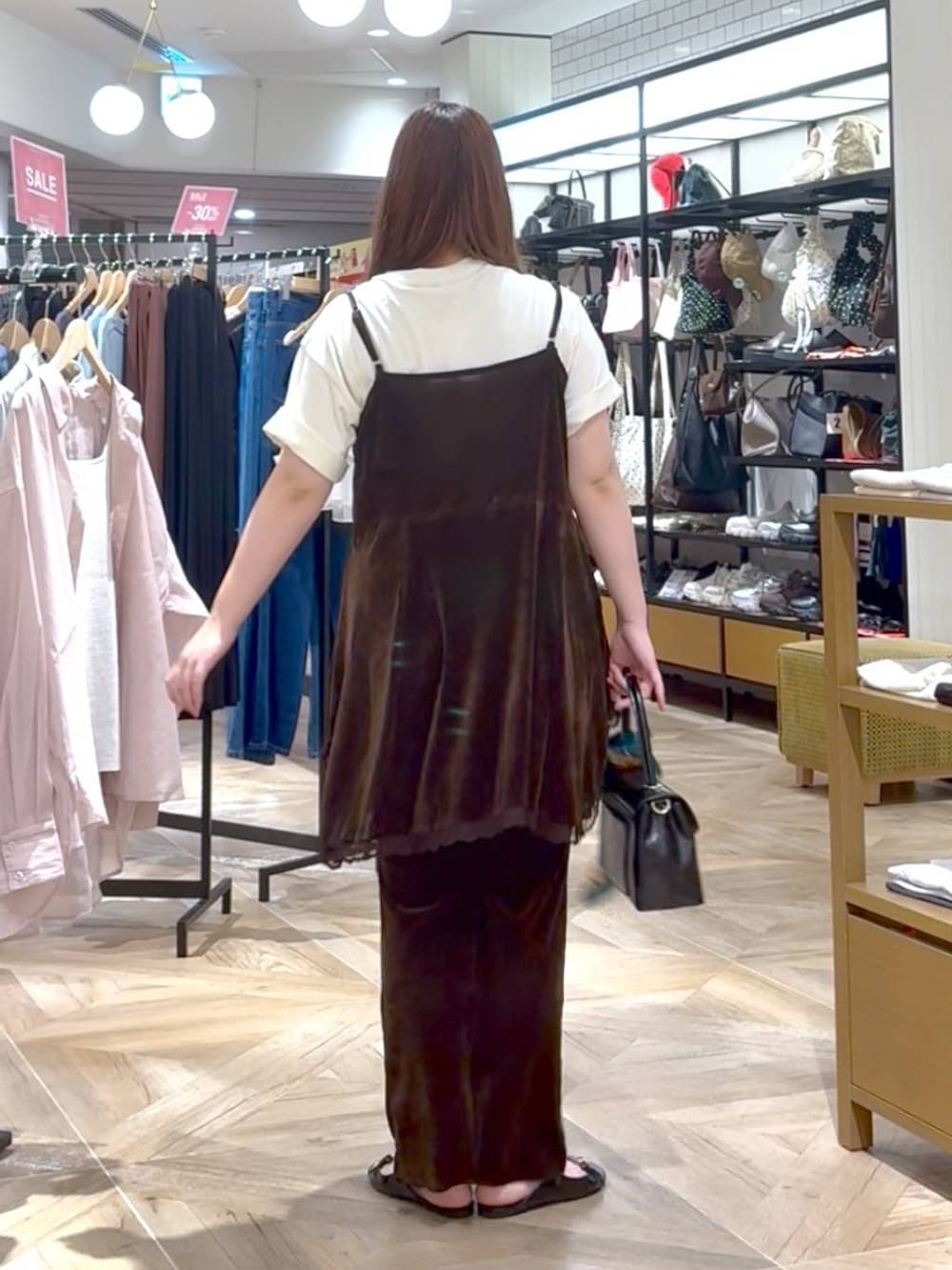 ブラック系のサンダル、ブラック系のボストンバッグ、ブラウン系のその他パンツを着用したレディースの夏コーディネートの3枚目の写真