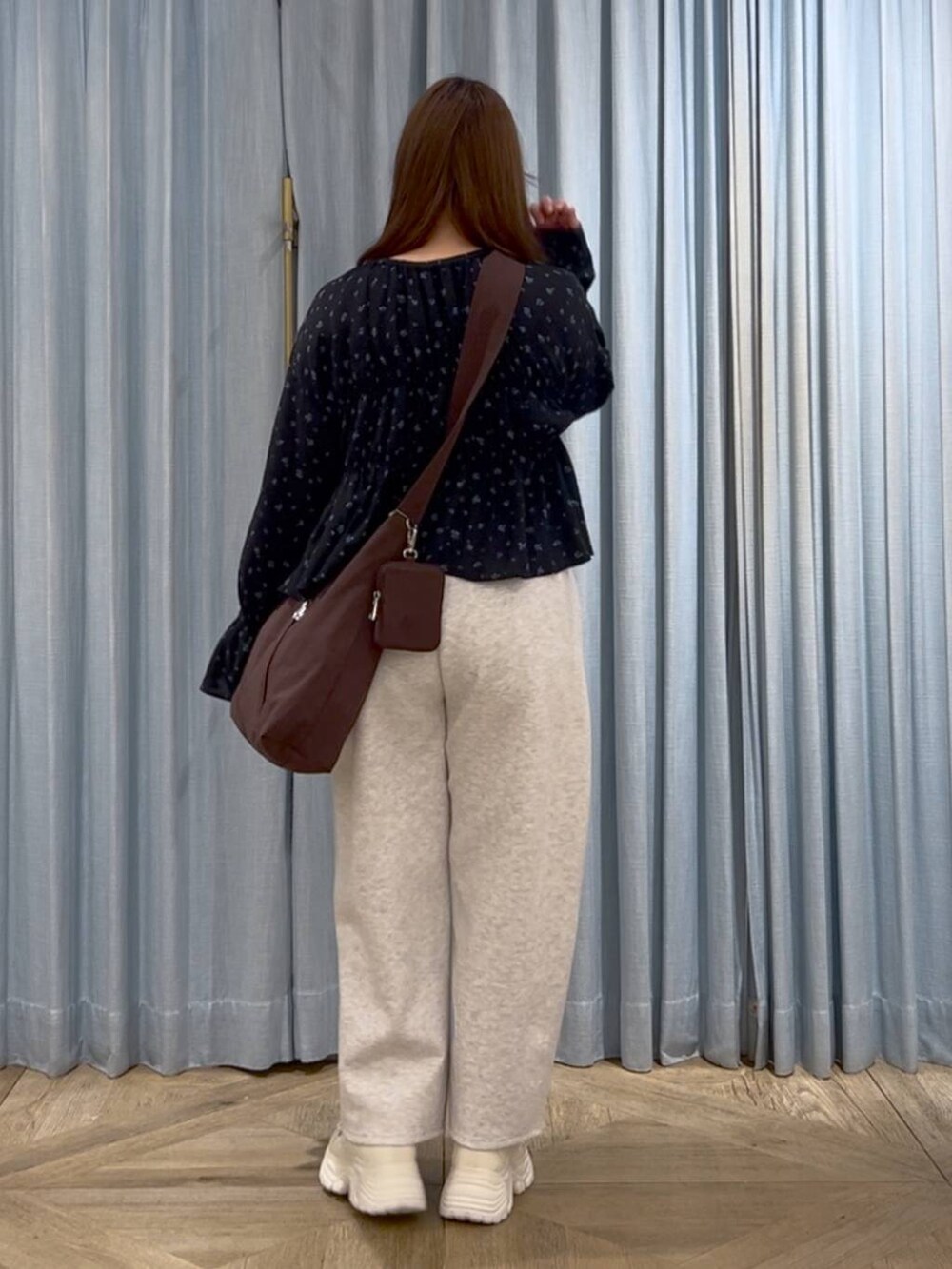 ブラウン系のショルダーバッグ、ホワイト系のスニーカー、グレー系のスウェットパンツを着用したレディースの春コーディネートの3枚目の写真