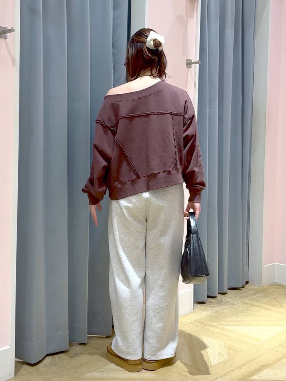 ブラウン系のスウェット、グレー系のスウェットパンツ、ブラック系のショルダーバッグを着用したレディースの秋コーディネートの3枚目の写真