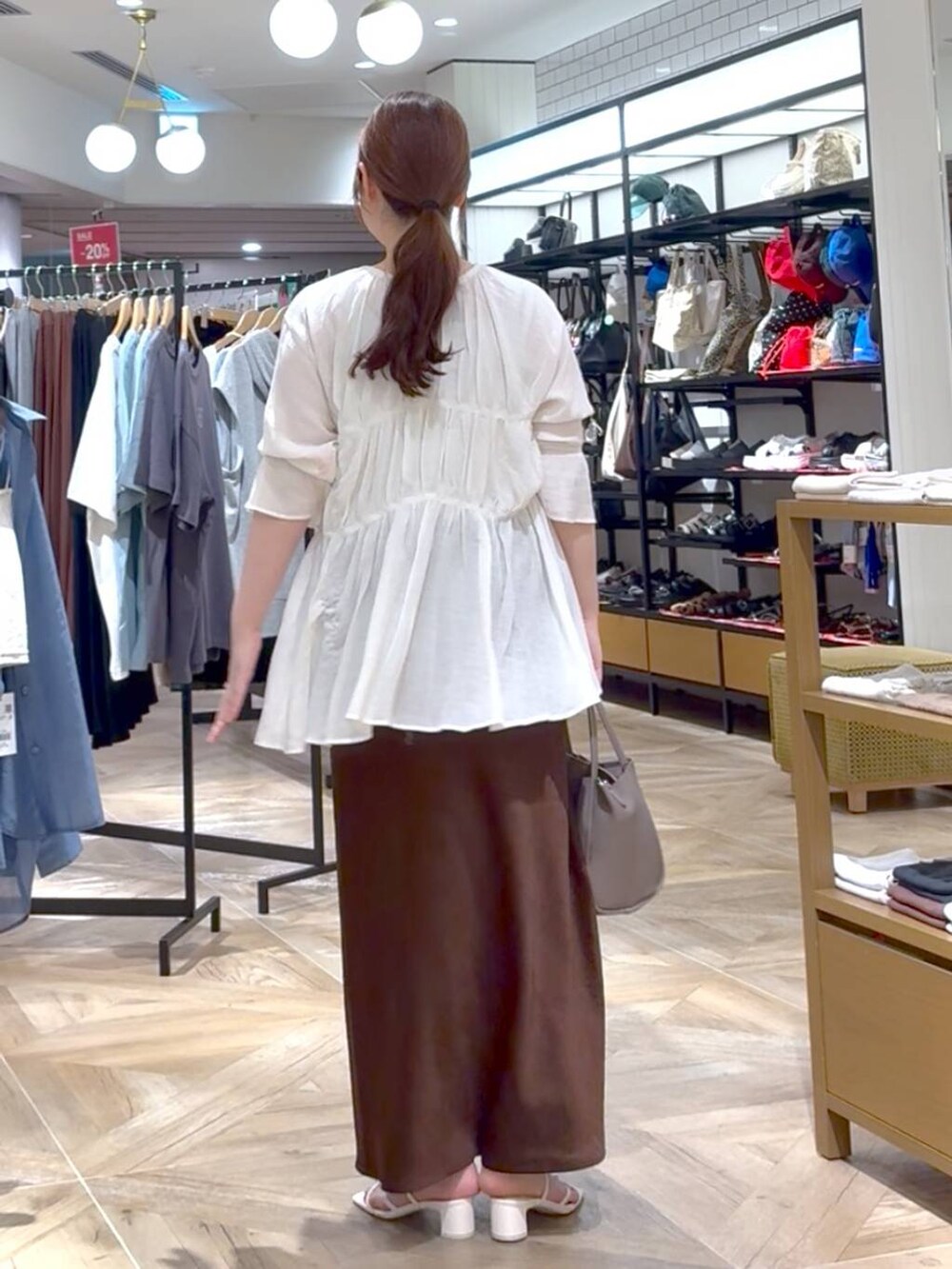 ホワイト系のシャツ/ブラウス、ブラウン系のスカート、シルバー系のタンクトップを着用したレディースの夏コーディネートの3枚目の写真