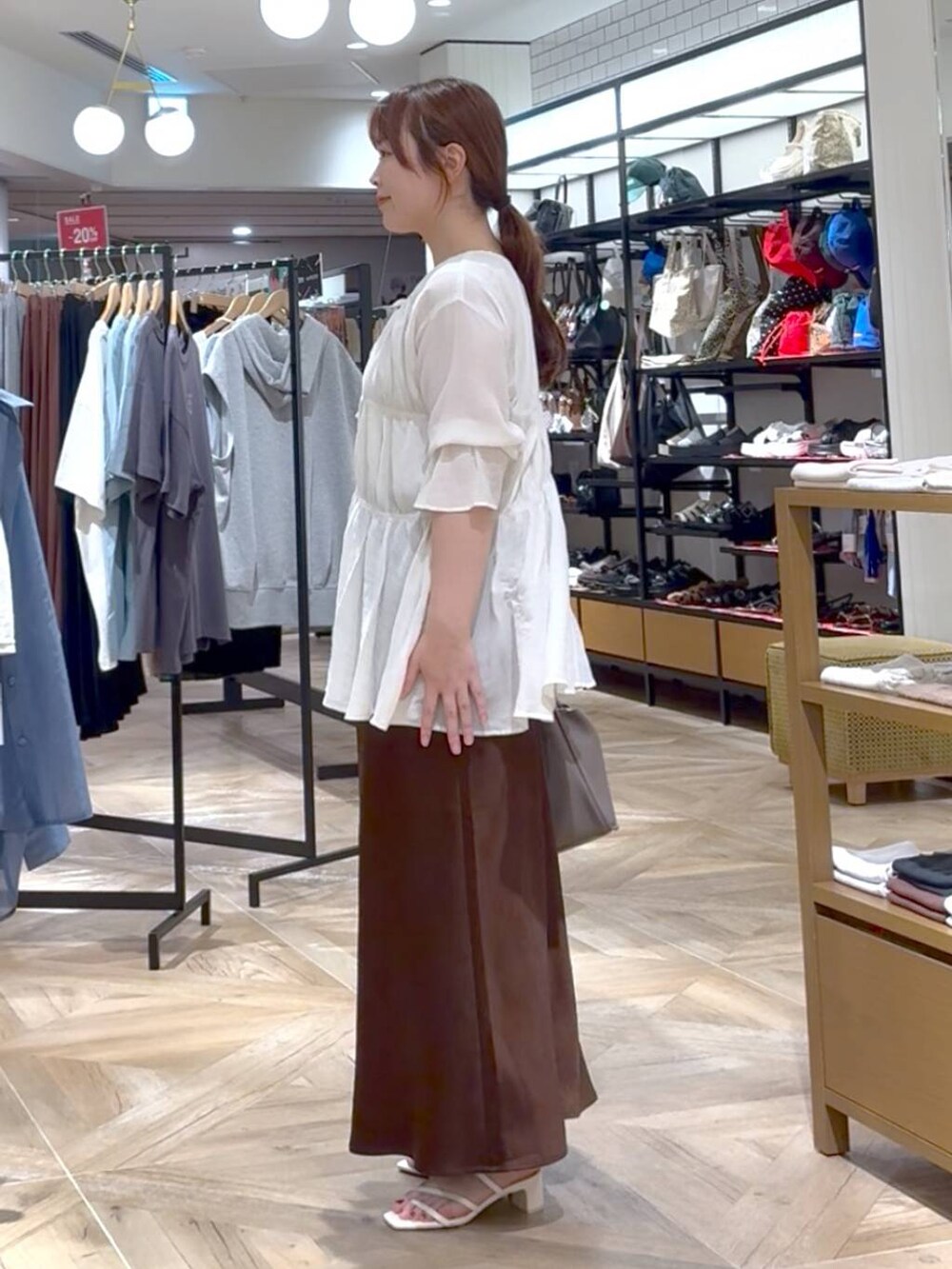 ホワイト系のシャツ/ブラウス、ブラウン系のスカート、シルバー系のタンクトップを着用したレディースの夏コーディネートの2枚目の写真