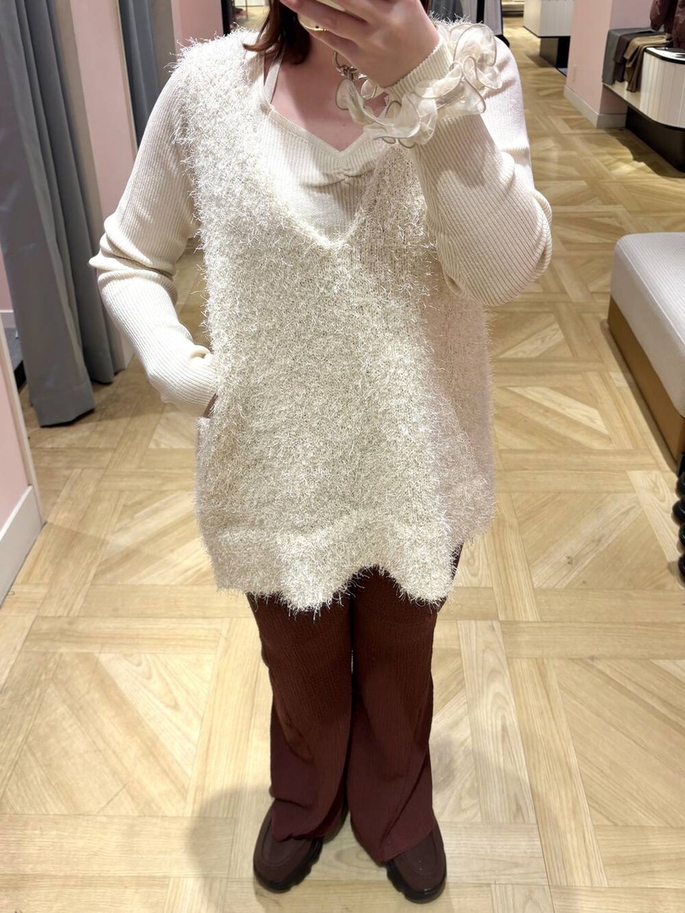 ブラウン系のローファー、ホワイト系のニット/セーター、ホワイト系のベストを着用したレディースの冬コーディネートの2枚目の写真