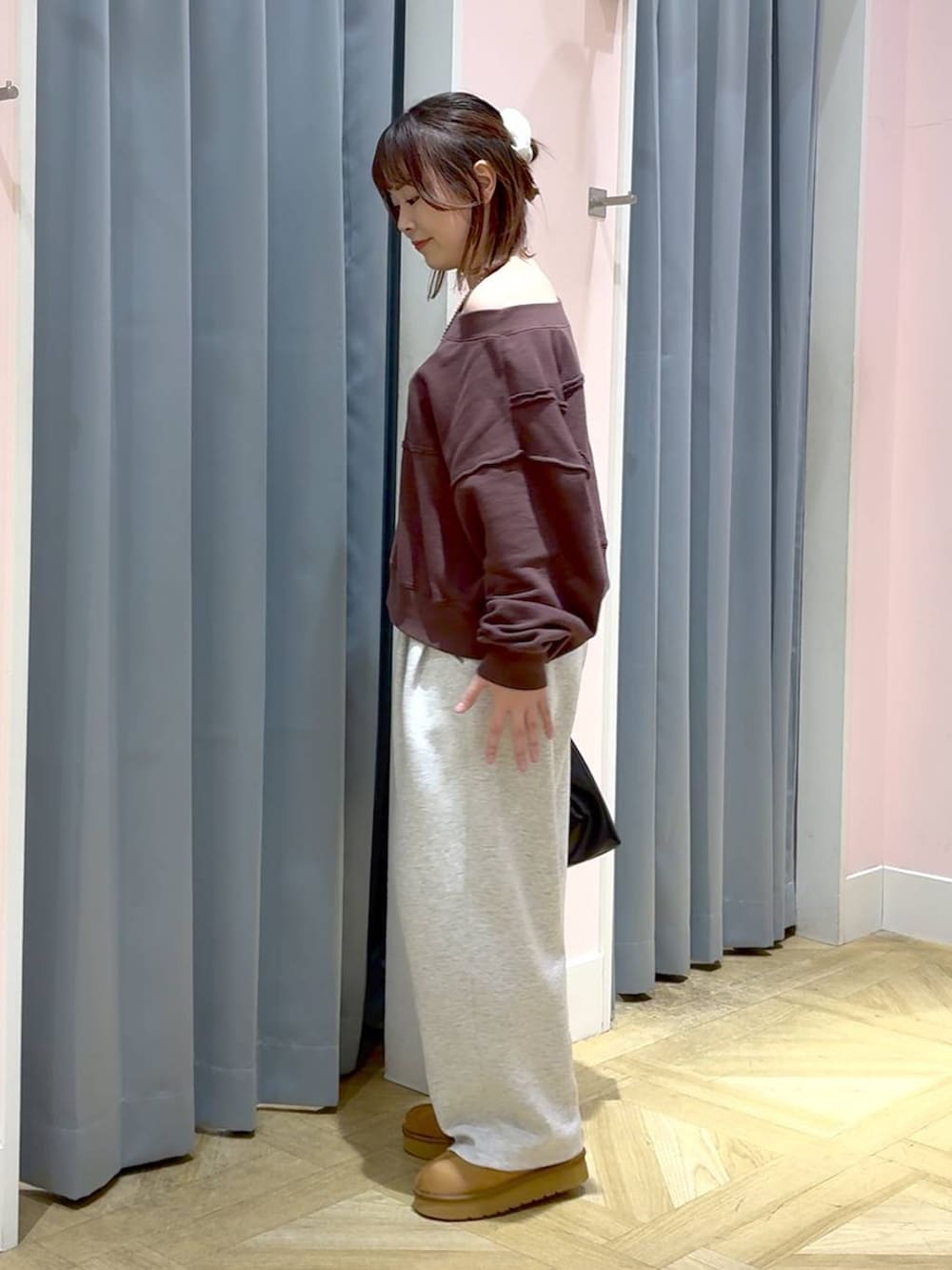 ブラウン系のスウェット、グレー系のスウェットパンツ、ブラック系のショルダーバッグを着用したレディースの秋コーディネートの2枚目の写真