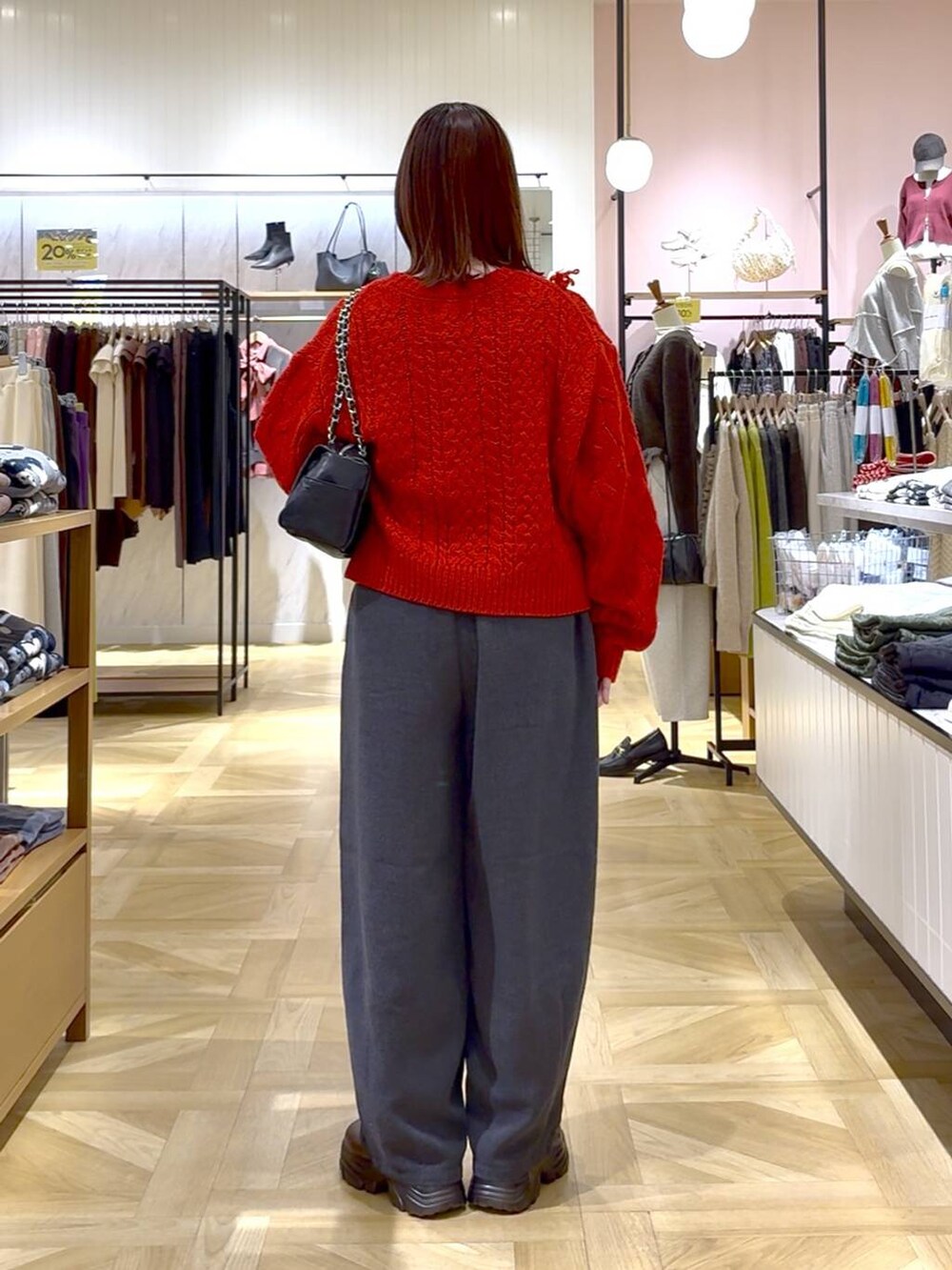 グレー系のその他パンツ、レッド系のポロシャツ、ブラック系のショルダーバッグを着用したレディースの秋コーディネートの3枚目の写真