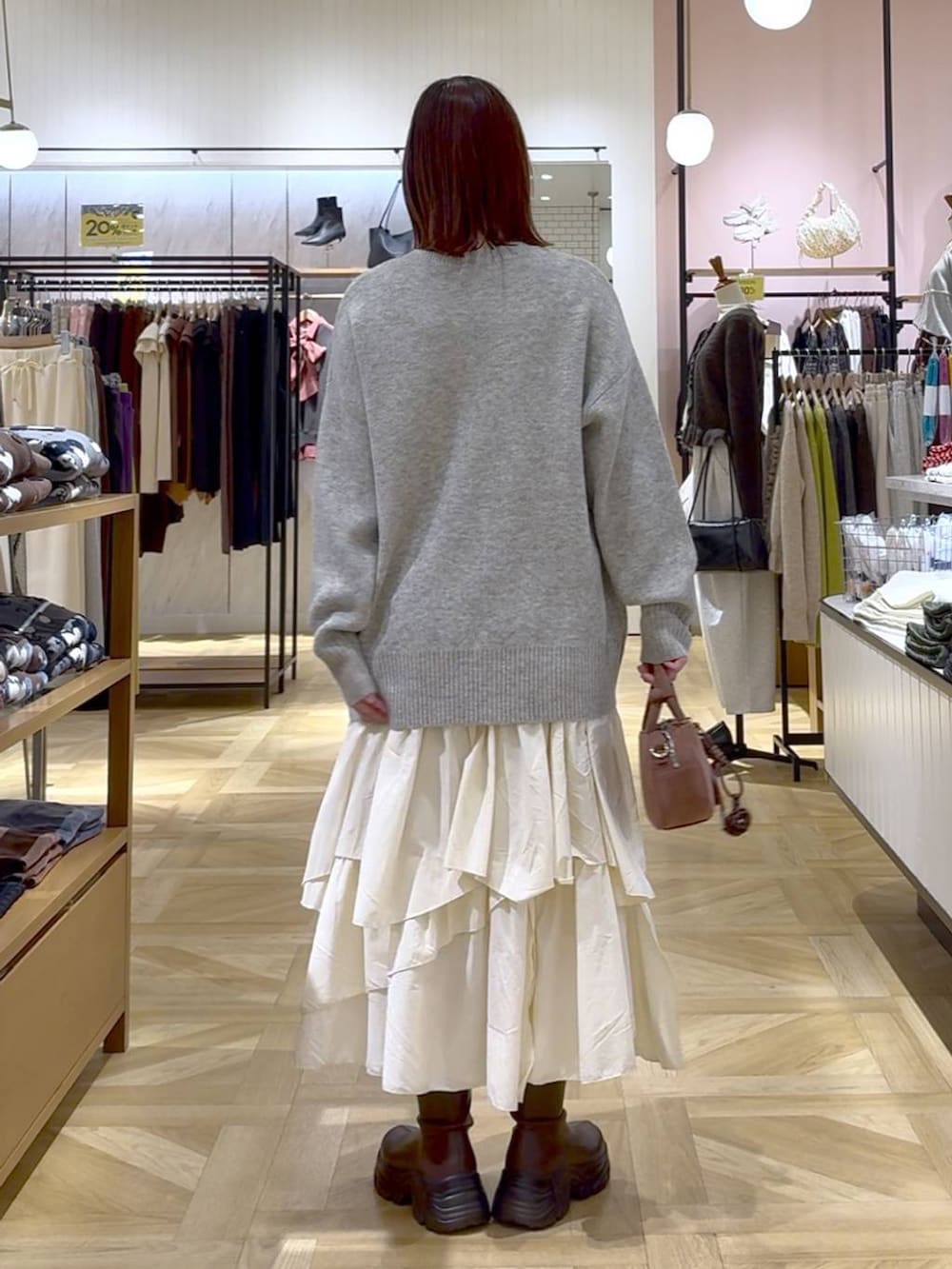 ブラウン系のブーツ、ホワイト系のスカート、ブラウン系のブルゾンを着用したレディースの秋コーディネートの5枚目の写真