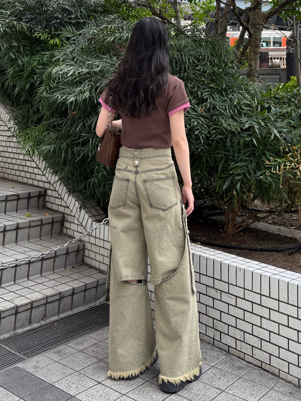 ブラウン系のハンドバッグ、ベージュ系のデニムパンツ、ブラウン系のTシャツ/カットソーを着用したレディースの春コーディネートの3枚目の写真