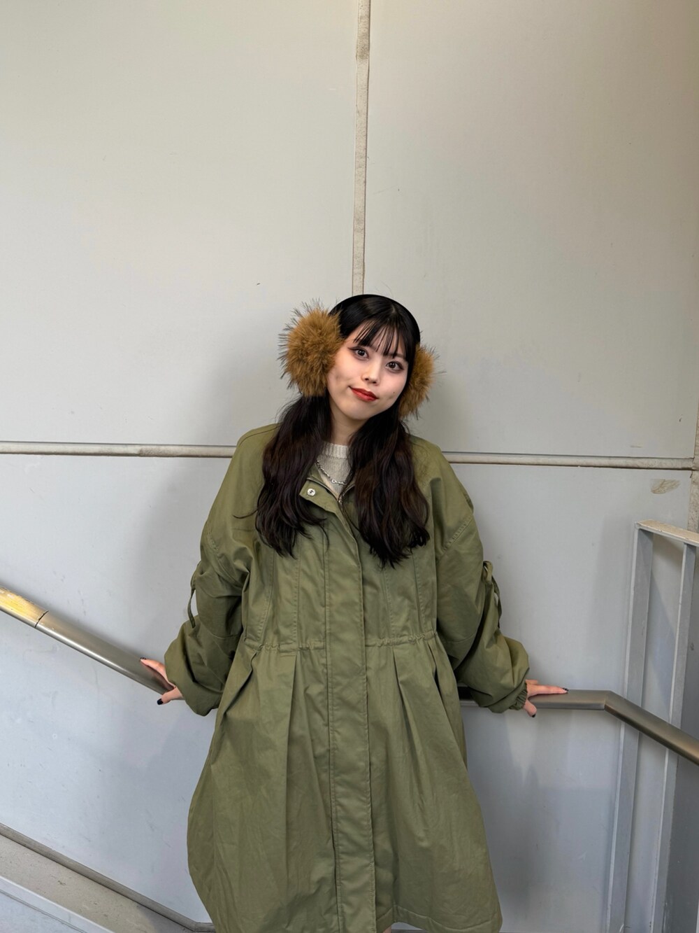 ブラック系のブーツ、グリーン系のモッズコート、ベージュ系のイヤーマフを着用したレディースの秋コーディネートの5枚目の写真