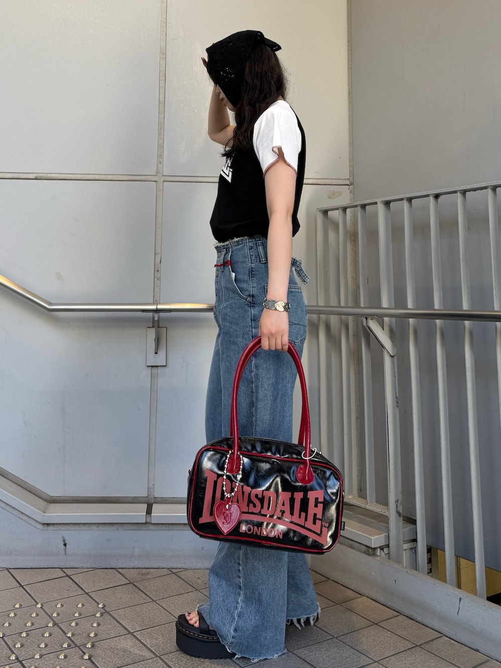 ブラック系のボストンバッグ、ブルー系のデニムパンツ、ブラック系のTシャツ/カットソーを着用したレディースの夏コーディネートの2枚目の写真