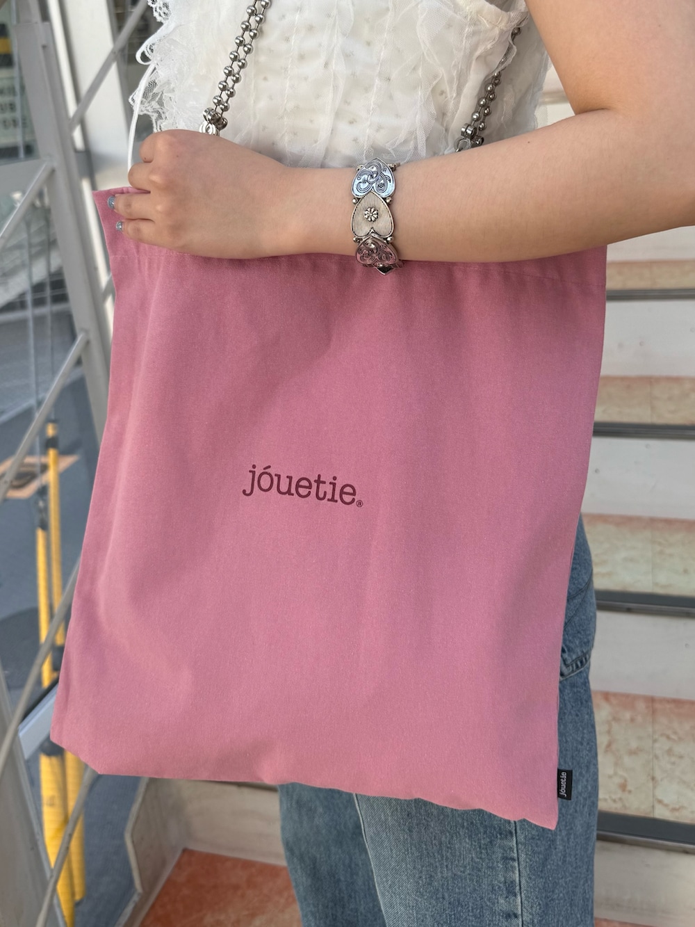 ホワイト系のタンクトップ、ホワイト系のベスト、ピンク系のトートバッグを着用したレディースの夏コーディネートの7枚目の写真