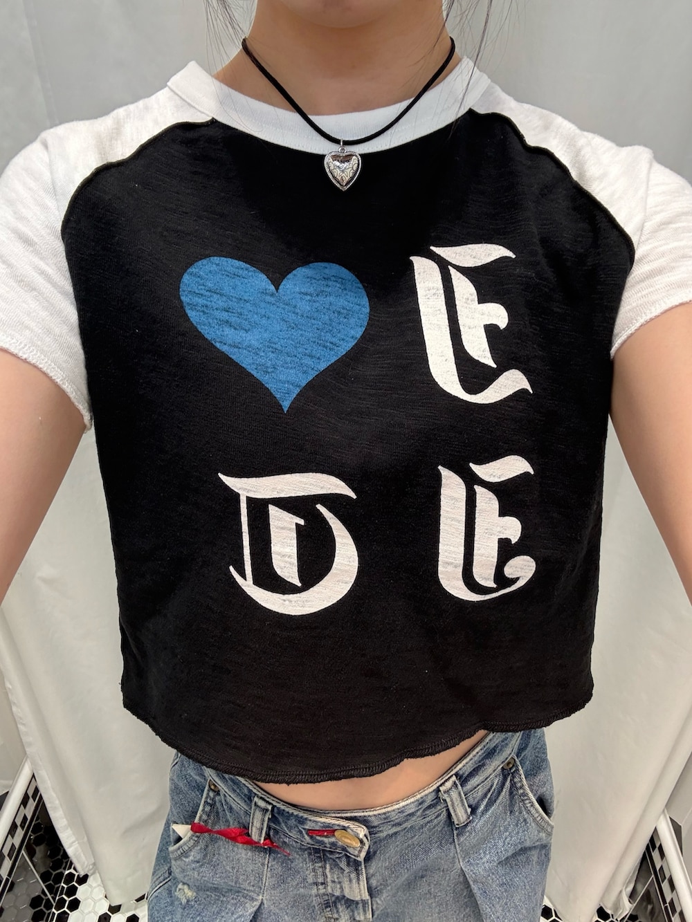ブラック系のTシャツ/カットソー、ブルー系のデニムパンツ、シルバー系のチョーカーを着用したレディースの夏コーディネートの5枚目の写真