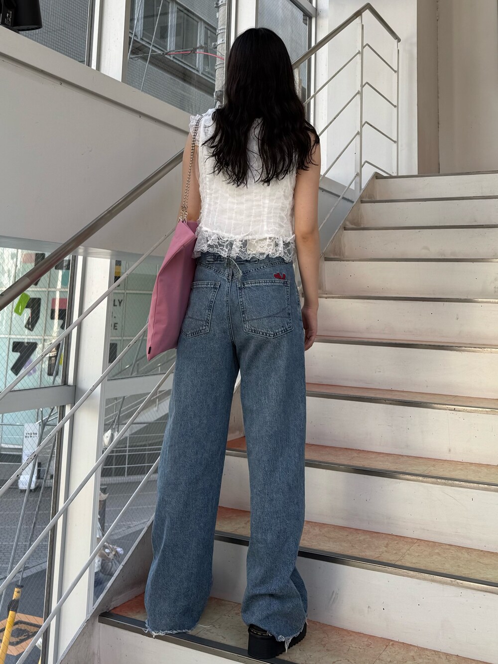 ホワイト系のタンクトップ、ホワイト系のベスト、ピンク系のトートバッグを着用したレディースの夏コーディネートの3枚目の写真