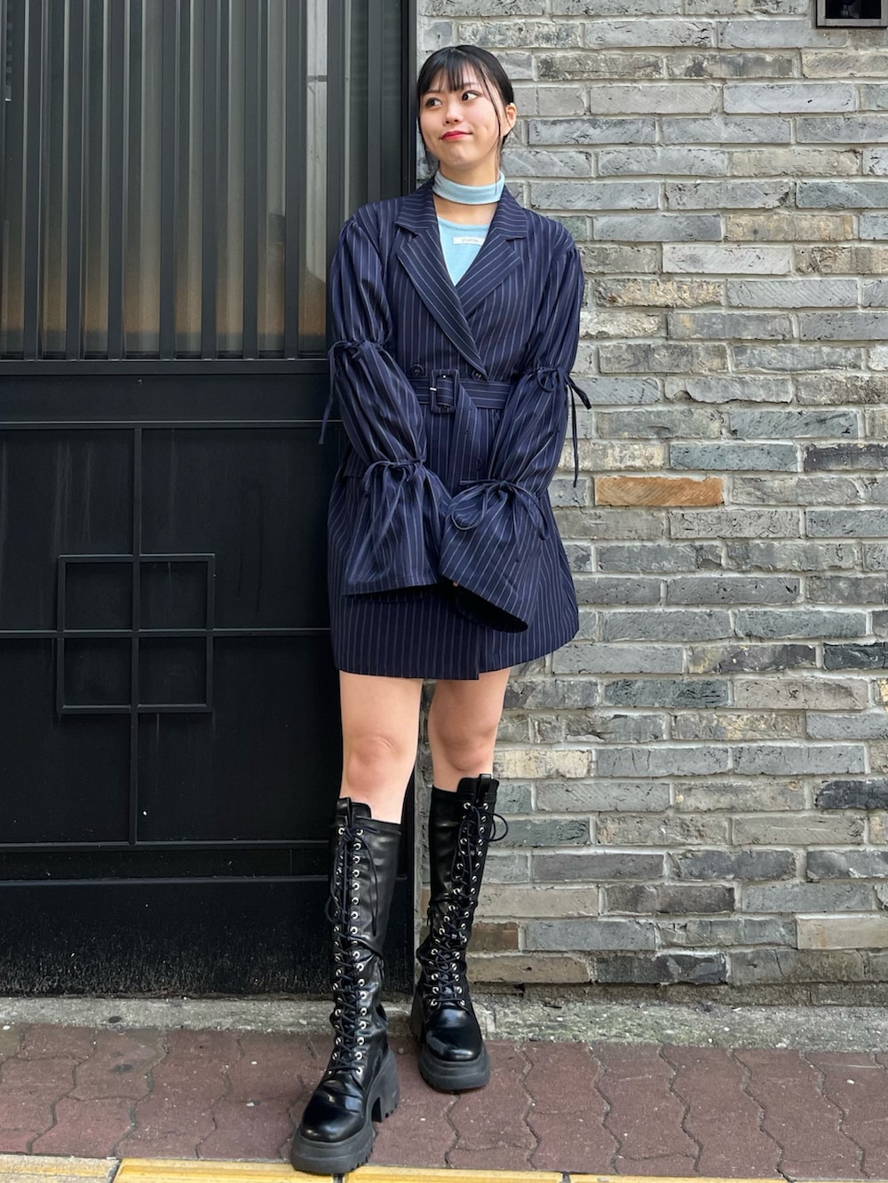 ブルー系のニット/セーター、ブルー系のテーラードジャケット、ブラック系のブーツを着用したレディースの冬コーディネートの2枚目の写真