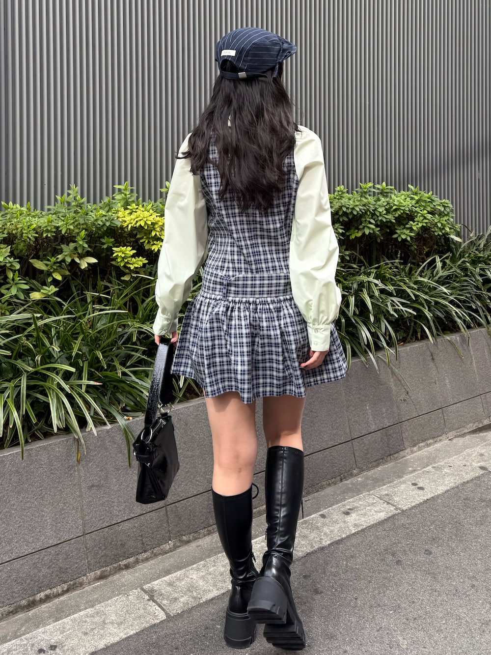 ブルー系のシャツワンピース、ブラック系のブーツ、ブラック系のハンドバッグを着用したレディースの冬コーディネートの4枚目の写真