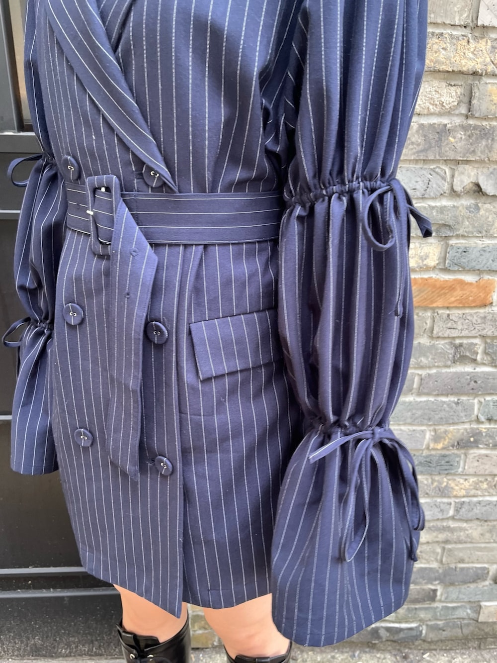 ブルー系のニット/セーター、ブルー系のテーラードジャケット、ブラック系のブーツを着用したレディースの冬コーディネートの6枚目の写真