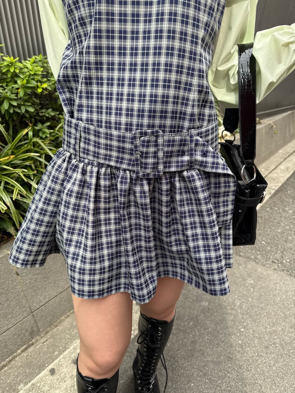 ブルー系のシャツワンピース、ブラック系のブーツ、ブラック系のハンドバッグを着用したレディースの冬コーディネートの7枚目の写真