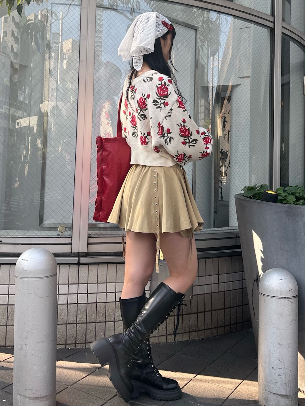 ホワイト系のカーディガン/ボレロ、ベージュ系のスカート、レッド系のトートバッグを着用したレディースの冬コーディネートの3枚目の写真