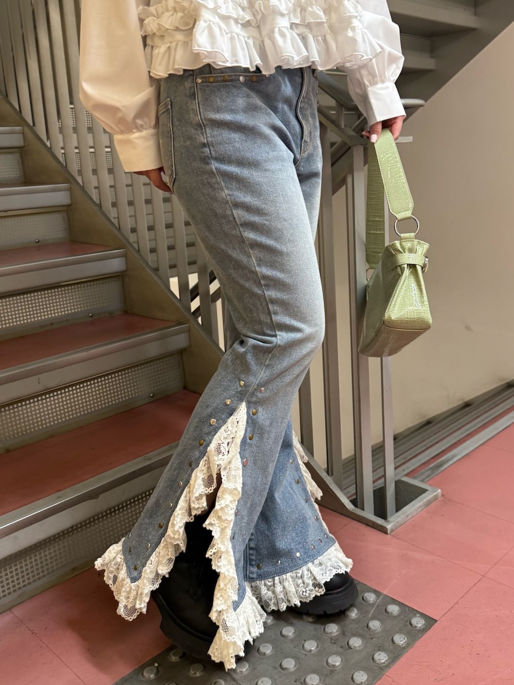 グリーン系のハンドバッグ、ホワイト系のシャツ/ブラウス、ブルー系のデニムパンツを着用したレディースの冬コーディネートの6枚目の写真