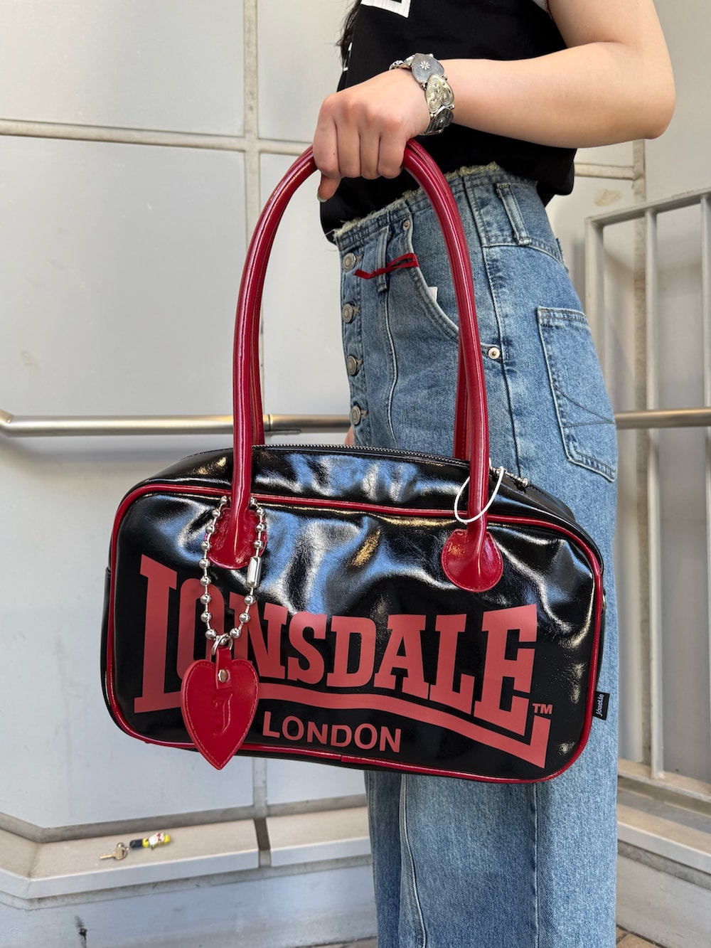 ブラック系のボストンバッグ、ブルー系のデニムパンツ、ブラック系のTシャツ/カットソーを着用したレディースの夏コーディネートの7枚目の写真