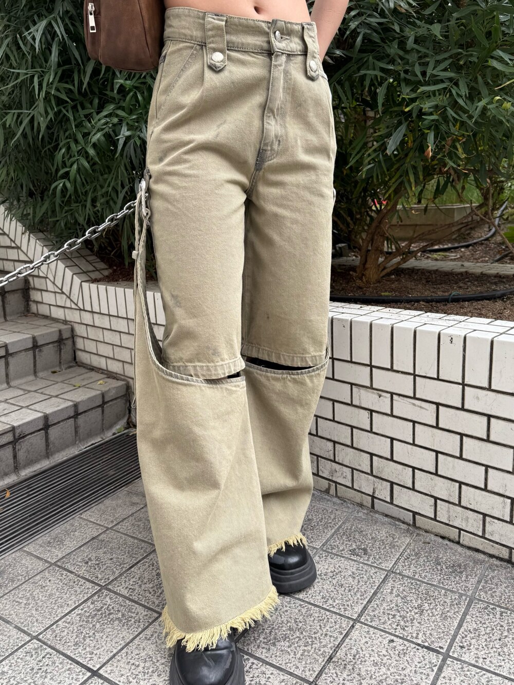 ブラウン系のハンドバッグ、ベージュ系のデニムパンツ、ブラウン系のTシャツ/カットソーを着用したレディースの春コーディネートの6枚目の写真