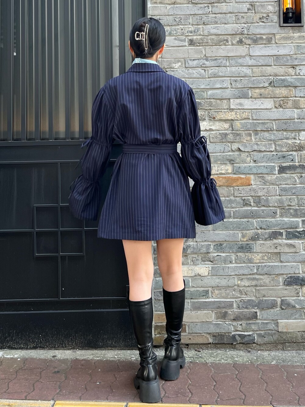 ブルー系のニット/セーター、ブルー系のテーラードジャケット、ブラック系のブーツを着用したレディースの冬コーディネートの4枚目の写真