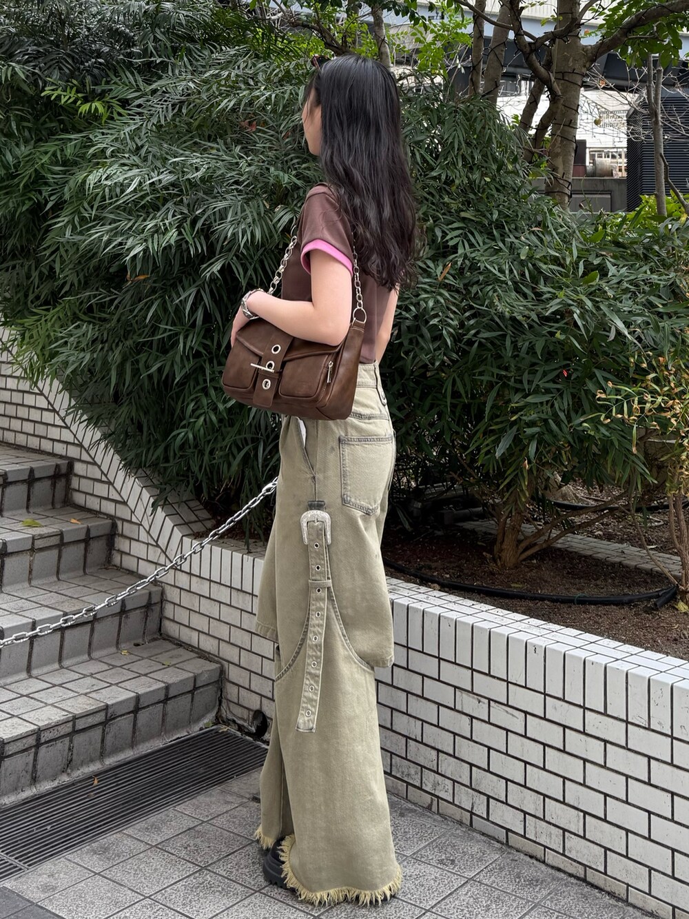 ブラウン系のハンドバッグ、ベージュ系のデニムパンツ、ブラウン系のTシャツ/カットソーを着用したレディースの春コーディネートの2枚目の写真