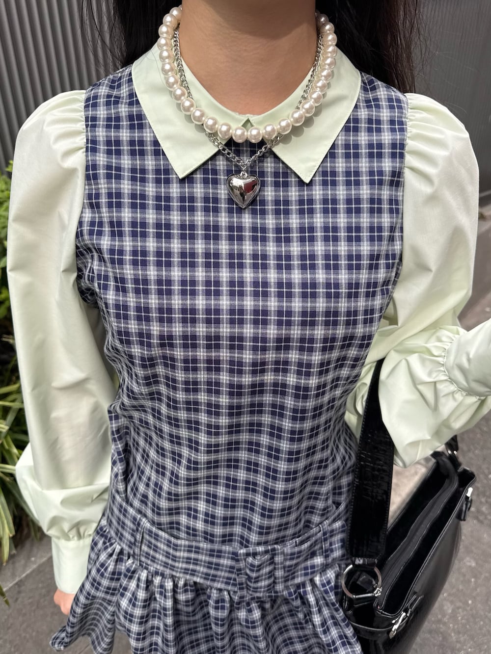 ブルー系のシャツワンピース、ブラック系のブーツ、ブラック系のハンドバッグを着用したレディースの冬コーディネートの6枚目の写真