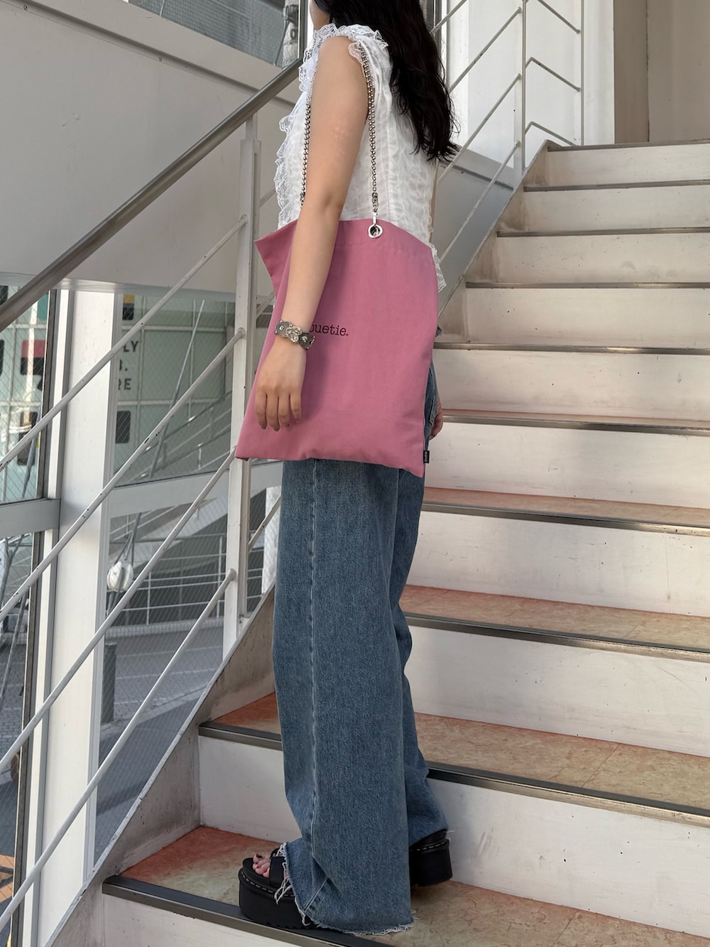 ホワイト系のタンクトップ、ホワイト系のベスト、ピンク系のトートバッグを着用したレディースの夏コーディネートの2枚目の写真