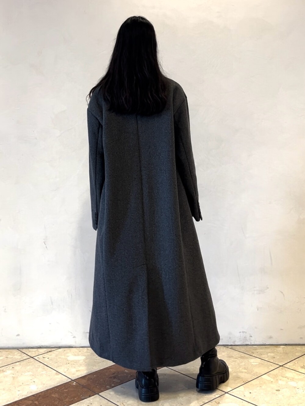 ホワイト系のニット/セーター、グレー系のチェスターコート、ブラウン系のその他パンツを着用したレディースの冬コーディネートの3枚目の写真