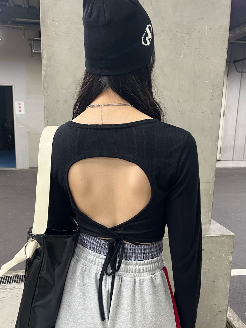 ブラック系のトートバッグ、ブラック系のTシャツ/カットソー、グレー系のスウェットパンツを着用したレディースの春コーディネートの6枚目の写真