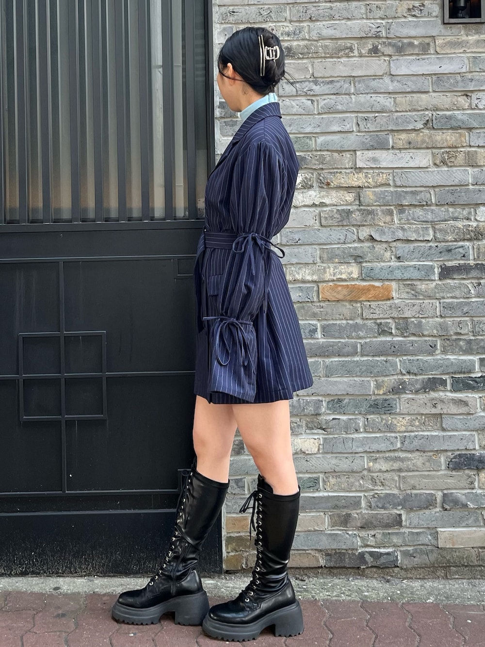 ブルー系のニット/セーター、ブルー系のテーラードジャケット、ブラック系のブーツを着用したレディースの冬コーディネートの3枚目の写真