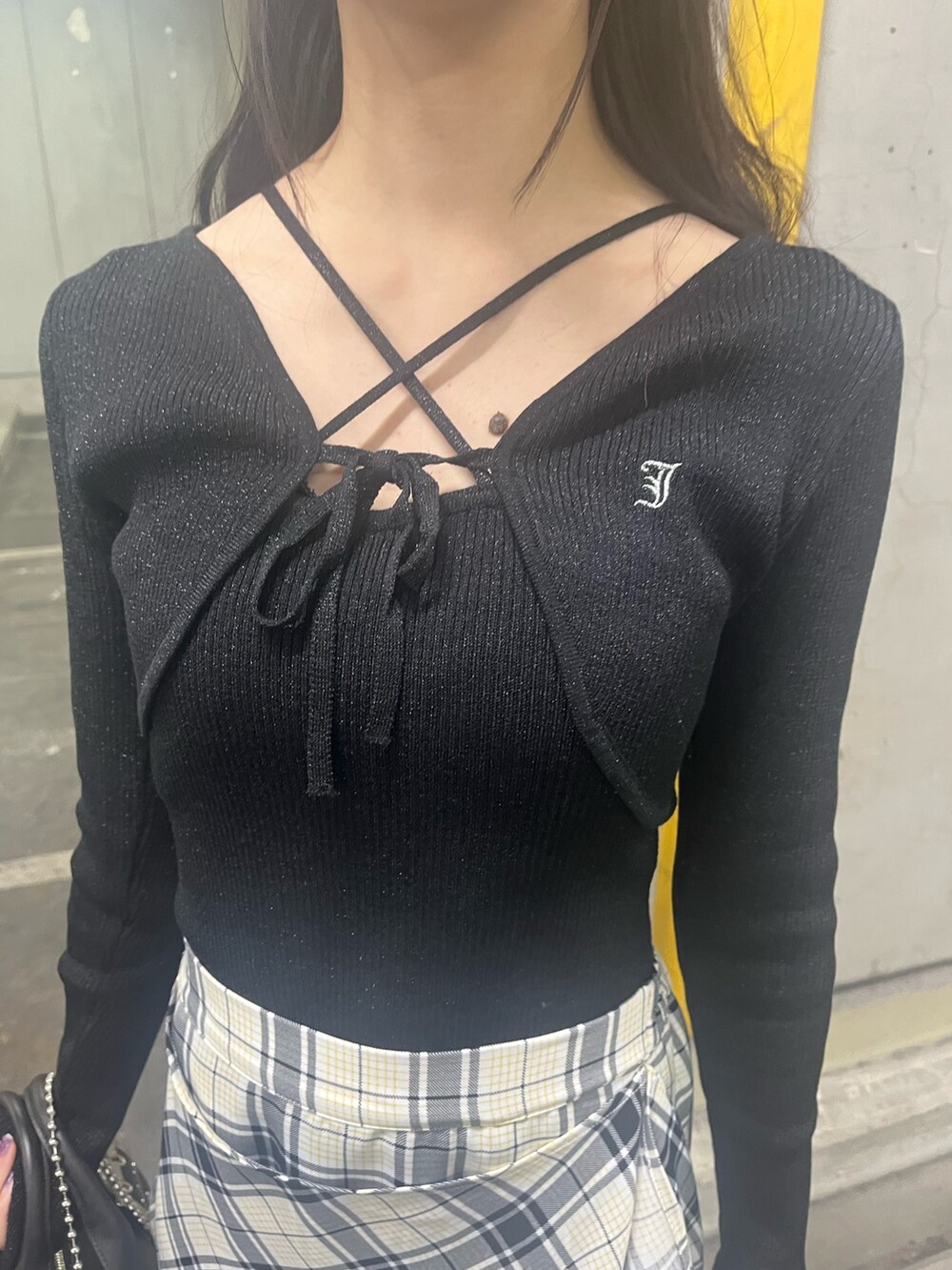 ブラック系のアンサンブル、ブラック系のボストンバッグ、ホワイト系のスカートを着用したレディースの春コーディネートの4枚目の写真