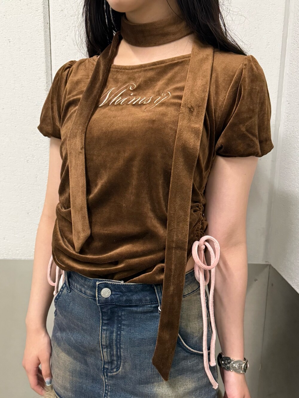 ブラウン系のTシャツ/カットソー、ブラック系のブーツ、ブルー系のスカートを着用したレディースの秋コーディネートの6枚目の写真