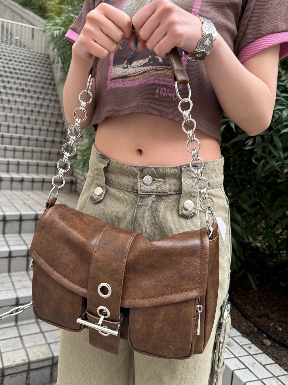 ブラウン系のハンドバッグ、ベージュ系のデニムパンツ、ブラウン系のTシャツ/カットソーを着用したレディースの春コーディネートの7枚目の写真