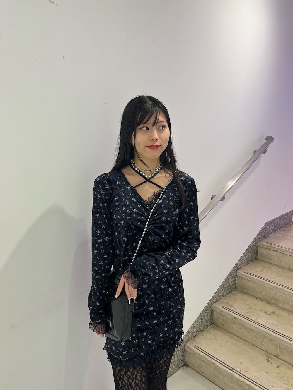 ブルー系のワンピース、ブラック系のハンドバッグ、ブラック系のその他パンツを着用したレディースの冬コーディネートの4枚目の写真