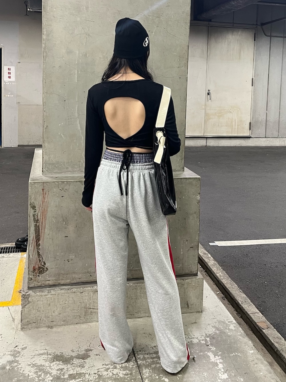 ブラック系のトートバッグ、ブラック系のTシャツ/カットソー、グレー系のスウェットパンツを着用したレディースの春コーディネートの3枚目の写真