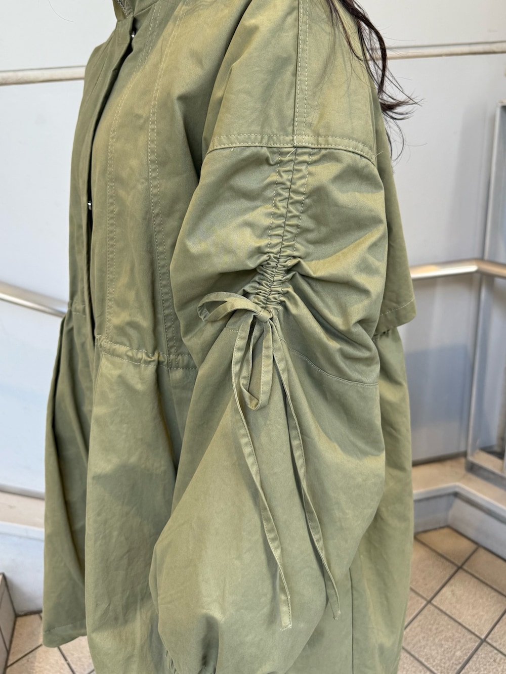 ブラック系のブーツ、グリーン系のモッズコート、ベージュ系のイヤーマフを着用したレディースの秋コーディネートの6枚目の写真