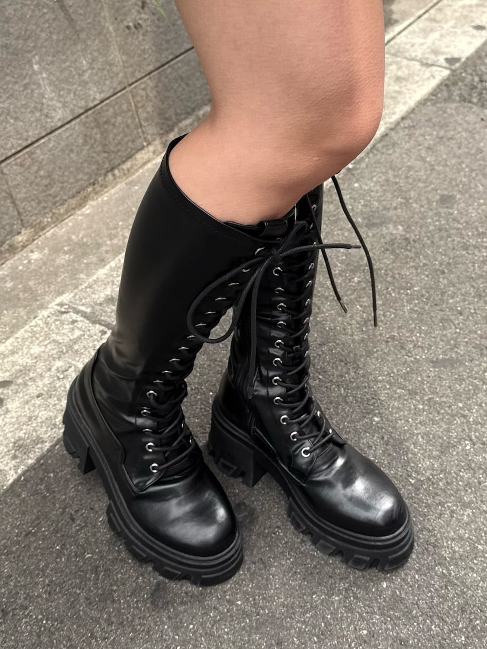 ブルー系のシャツワンピース、ブラック系のブーツ、ブラック系のハンドバッグを着用したレディースの冬コーディネートの8枚目の写真