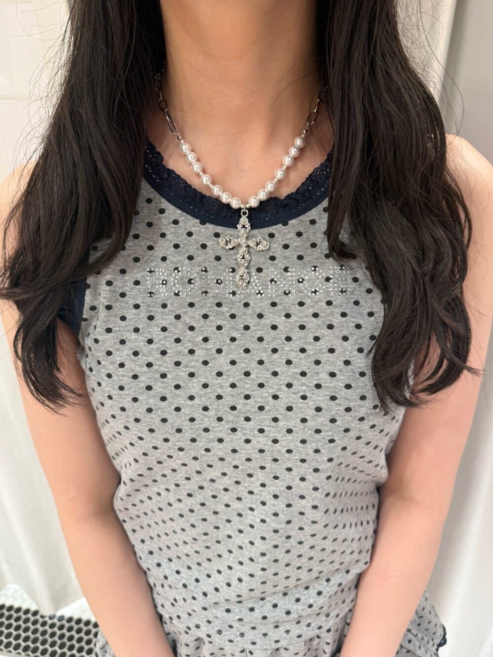 グレー系のタンクトップ、グレー系のスカート、ブラウン系のハンドバッグを着用したレディースの夏コーディネートの5枚目の写真