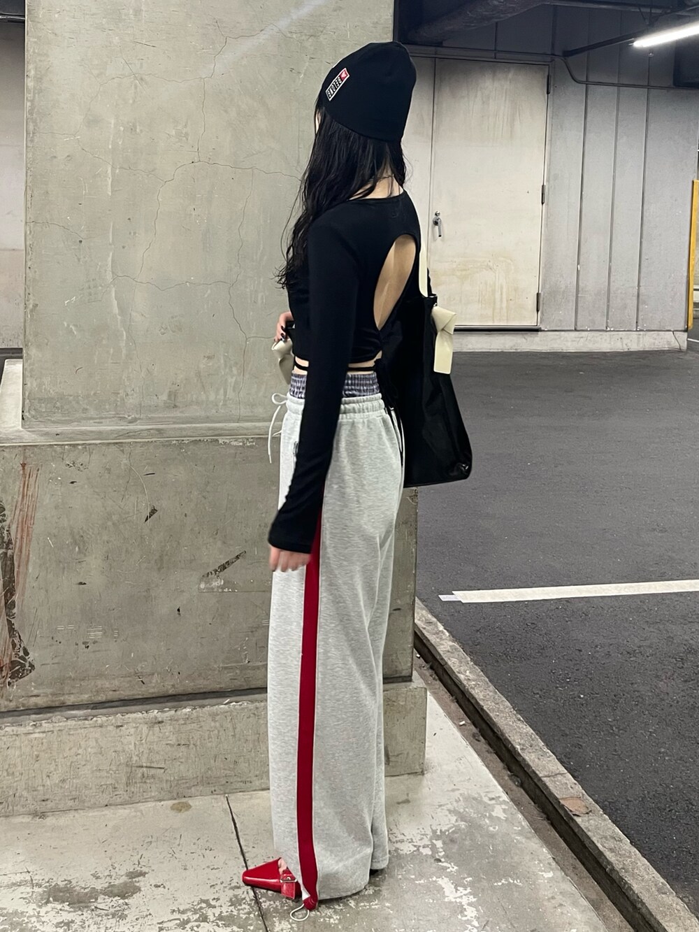 ブラック系のトートバッグ、ブラック系のTシャツ/カットソー、グレー系のスウェットパンツを着用したレディースの春コーディネートの2枚目の写真