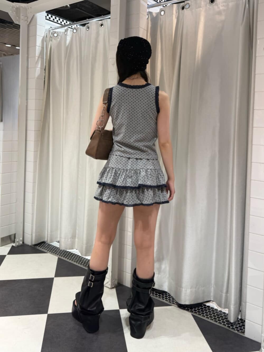 グレー系のタンクトップ、グレー系のスカート、ブラウン系のハンドバッグを着用したレディースの夏コーディネートの3枚目の写真