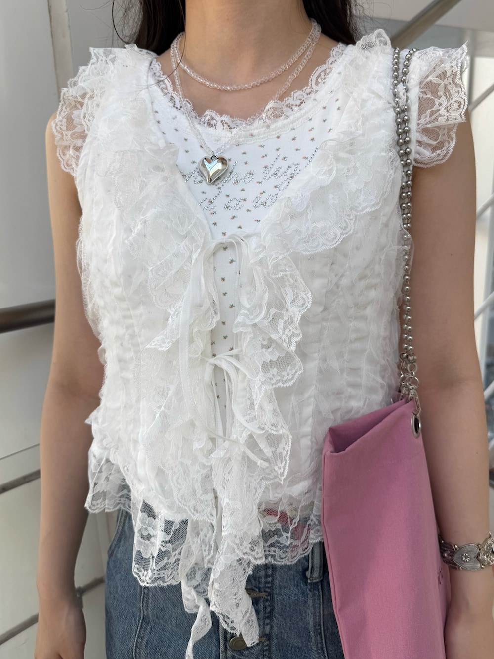 ホワイト系のタンクトップ、ホワイト系のベスト、ピンク系のトートバッグを着用したレディースの夏コーディネートの5枚目の写真