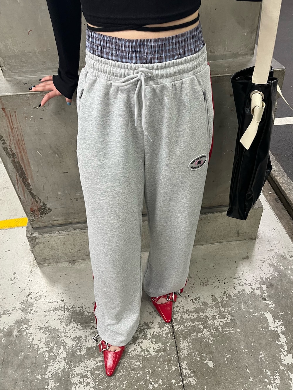 ブラック系のトートバッグ、ブラック系のTシャツ/カットソー、グレー系のスウェットパンツを着用したレディースの春コーディネートの7枚目の写真