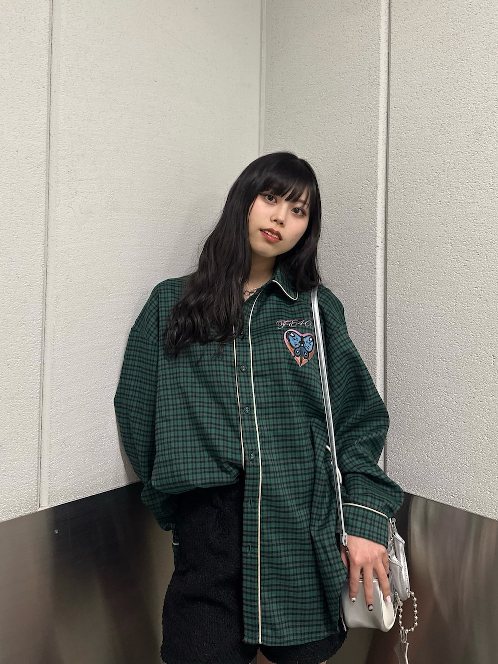 シルバー系のボストンバッグ、その他のシャツ/ブラウス、ブラック系のブーツを着用したレディースの冬コーディネートの4枚目の写真