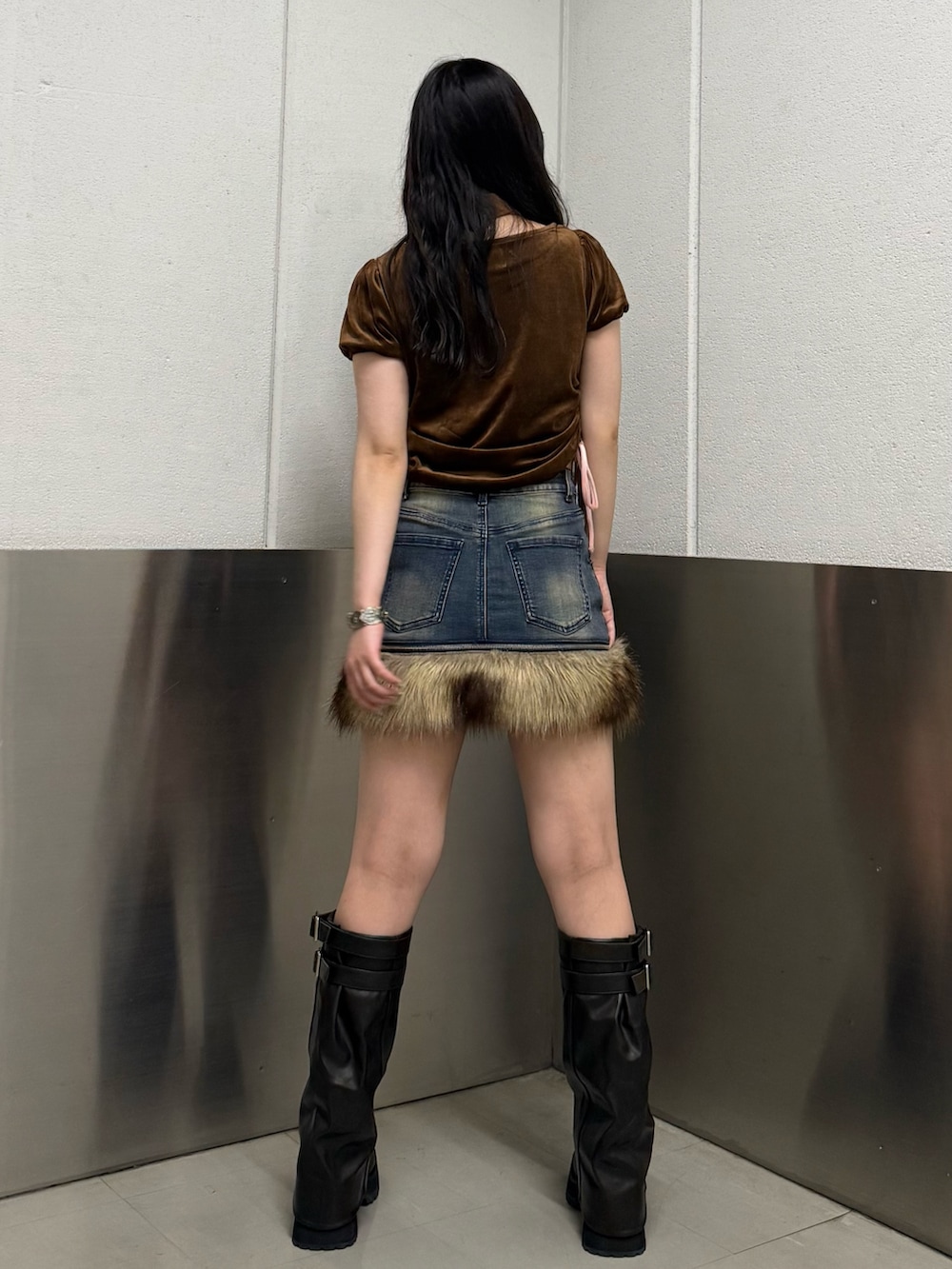 ブラウン系のTシャツ/カットソー、ブラック系のブーツ、ブルー系のスカートを着用したレディースの秋コーディネートの4枚目の写真