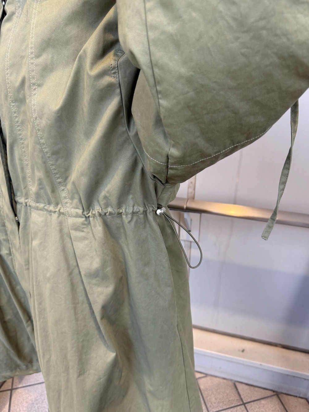 ブラック系のブーツ、グリーン系のモッズコート、ベージュ系のイヤーマフを着用したレディースの秋コーディネートの8枚目の写真