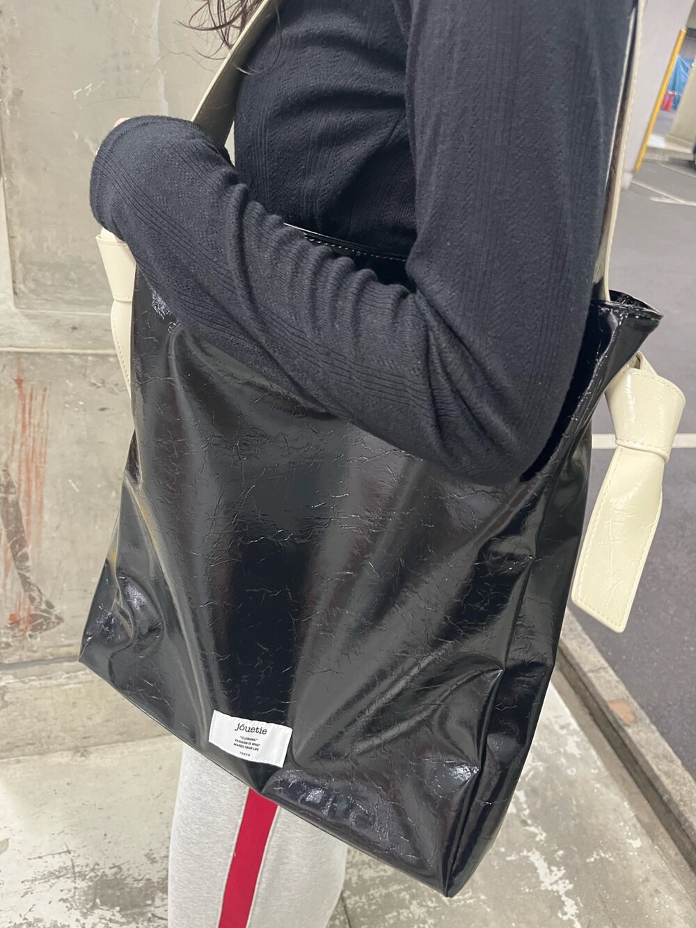 ブラック系のトートバッグ、ブラック系のTシャツ/カットソー、グレー系のスウェットパンツを着用したレディースの春コーディネートの9枚目の写真